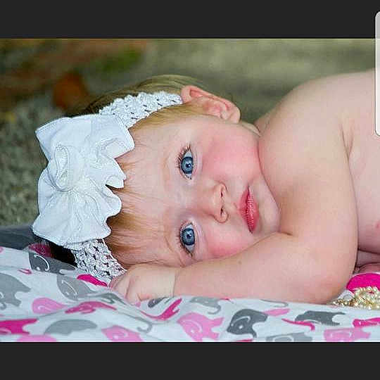 Gracelyn is registered to the contest to win money with this photo: cheek, child, eye, girl, hair_accessory, human_hair_color, infant, nose, photograph, pink, portrait_photography, skin, smile, toddler