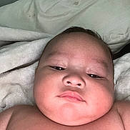 Kalijiah is registered to the contest to win money with this photo: baby, infant, face, skin, cheeks, expressionless, blanket, bed, closeup, portrait, child, lying_down, soft, indoors, newborn, resting, cuteness, young, person, head