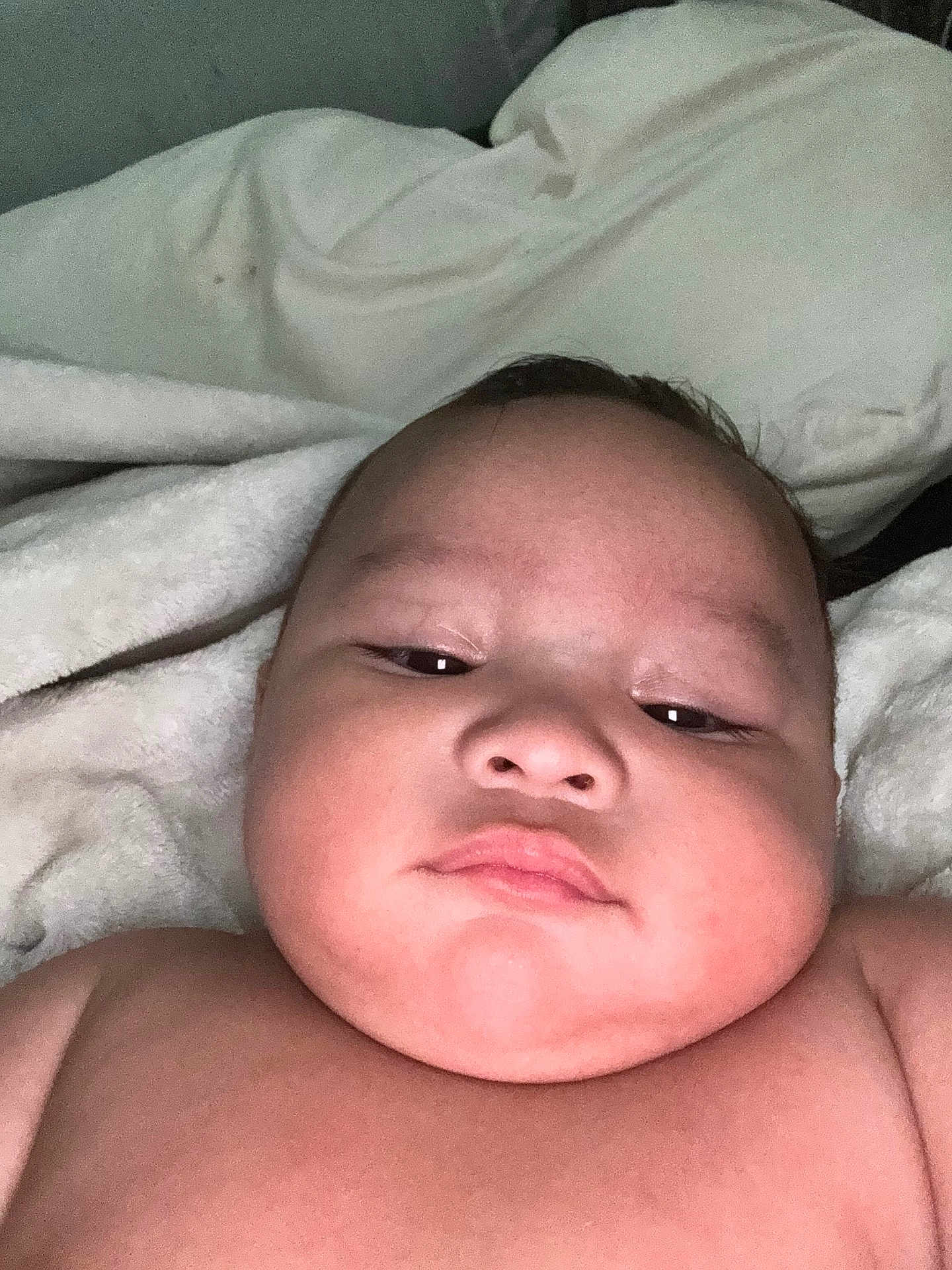 Kalijiah is registered to the contest to win money with this photo: baby, infant, face, skin, cheeks, expressionless, blanket, bed, closeup, portrait, child, lying_down, soft, indoors, newborn, resting, cuteness, young, person, head