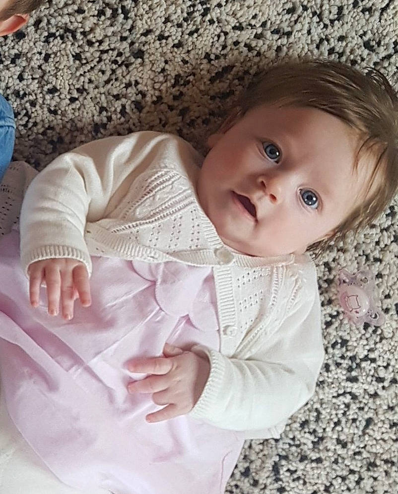 Madeleine participe au concours pour gagner de l'argent avec cette photo : arm, baby, baby_toddler_clothing, beauty, cheek, child, dress, eye, face, head, lip, nose, outerwear, person, pink, product, skin, sleeve, smile, textile