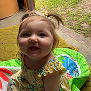 Remi joined the competition — help win amazing prizes! baby, child, pigtails, smile, yellow_dress, playmat, indoor, outdoor, grass, doorway, happy, cute, sitting, infant, colorful, person, young_child, joyful, playful, floor