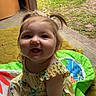 baby, child, pigtails, smile, yellow_dress, playmat, indoor, outdoor, grass, doorway, happy, cute, sitting, infant, colorful, person, young_child, joyful, playful, floor