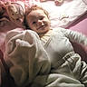 Lalia a rejoint le concours — aidez-le/la à gagner de superbes lots ! baby, bedroom, blanket, child, comfort, crib, cuddly, curly_hair, cute, happy, infant, pacifier, pink, plush_toy, rest, sleepwear, smile, soft_lighting, soft_texture, toy