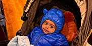 Neev is registered to the contest to win money with this photo: baby, child, stroller, blue_jacket, blanket, indoor, shopping, floor, wood_floor, clothing, hat, face, cute, warm, bundle, person, infant, coat, hood, toy