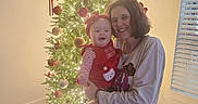 Paisley is registered to the contest to win money with this photo: baby, celebration, christmas_tree, family, festive, happy, headband, holding, holiday, indoor, joyful, lights, ornaments, portrait, red_clothing, smiling, together, window_blinds, woman, wood_floor