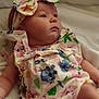 Paisley is registered to the contest to win money with this photo: baby, infant, headband, colorful_clothing, cartoon_print, lying_down, soft_surface, child, cute, calm_expression, skin, arm, leg, closeup, indoors, fabric, sleepwear, person, newborn, head