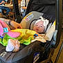 Paisley joined the competition — help win amazing prizes! baby, infant, car_seat, headband, bow, toy, hand, adult, restaurant, elderly, table, chair, people, indoor, clothing, person, seated, colorful, soft_toy, casual