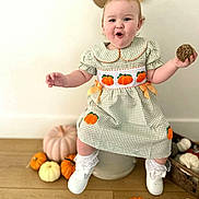 Paisley joined the competition — help win amazing prizes! baby, child, portrait, smiling, happy, autumn, pumpkin, pumpkin_dress, pinecone, bow, hair_bow, gingham, dress, lace_socks, white_shoes, sitting, indoor, wooden_floor, fall_decorations, seasonal