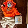 Elio participe au concours pour gagner de l'argent avec cette photo : baby, pacifier, orange_hoodie, cream_pants, blanket, brown_blanket, infant, smiling_cartoon, milestone_card, one_month, cute, child, indoors, soft_toys, winnie_the_pooh, baby_clothing, newborn, lying_down, celebration, colorful