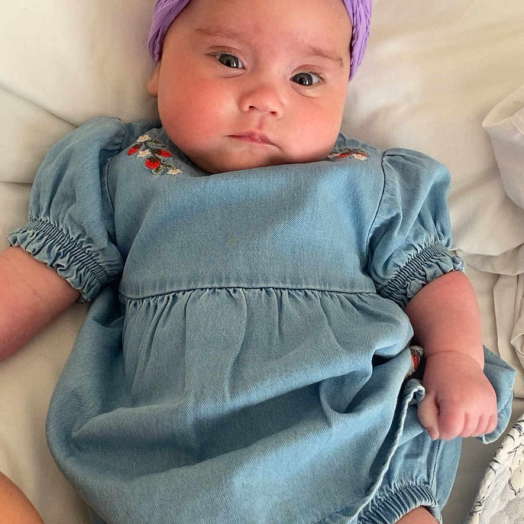 Susie-Leigh is registered to the contest to win money with this photo: baby, bed, cap, clothing, costume, cushion, dress, face, furniture, hat, head, homedecor, jeans, newborn, pants, person, photography, portrait, purple, shorts