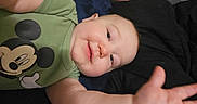 Dean joined the competition — help win amazing prizes! baby, child, mickey_mouse, green_shirt, smile, face, hand, arm, lying_down, blanket, blue_blanket, black_blanket, indoor, cute, infant, person, portrait, young_child, reaching, happy
