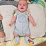 baby, child, smiling, blue_overalls, socks, blanket, toys, play_mat, floor, happy, infant, indoor, cute, lying_down, patterned, striped_clothing, wooden_floor, paciifier, colorful, soft_texture