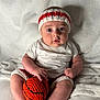 Dakeem joined the competition — help win amazing prizes! baby, infant, child, knitted_headband, knitted_shorts, crocheted_basketball, white_blanket, soft_texture, cute, chubby_cheeks, sitting, indoors, portrait, hand, foot, expression, face, clothing, toy, playful