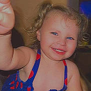 Violet is registered to the contest to win money with this photo: toddler, child, smiling, curly_hair, blue_eyes, dress, patterned_clothing, indoor, wall_decor, happy, person, portrait, cute, young_child, reaching_hand, colorful, face, skin, light, expression