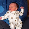 baby, blanket, blue, cat_pattern, clothing, cozy, eyes_closed, face, indoor, infant, lying_down, newborn, onesie, pajamas, peaceful, person, photograph, portrait, raised_fist, sleeping