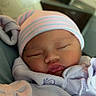 baby, blanket, burrito_baby, close_up, clothing, cozy, face, hat, hospital, indoors, infant, newborn, pastel_colors, peaceful, portrait, resting, sleeping, soft_lighting, striped_hat, swaddled