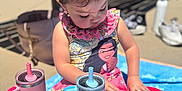 Mariella is registered to the contest to win money with this photo: bench, blue, blue_towel, child, concrete, cute, dress, focused, hair_tied, outdoor, picnic, pink, playing, shoes, sippy_cup, snack_box, summer, sunny, toddler, water_bottle