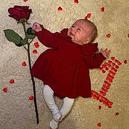 Alba participe au concours pour gagner de l'argent avec cette photo : adorable, baby, carpet, celebration, cute, decorations, happy, heart_shapes, indoors, infant, love_theme, lying_down, person, portrait, red_dress, rose, small_feet, small_hands, soft_texture, white_tights