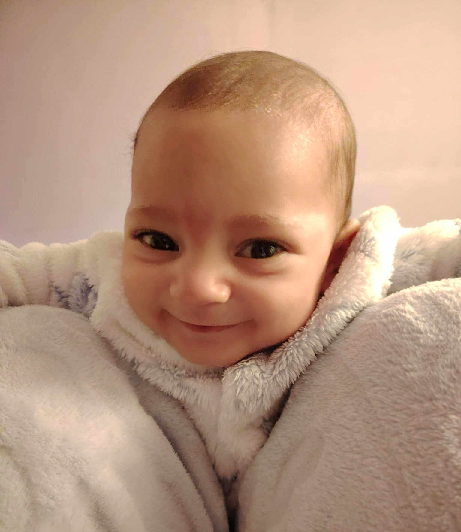 Lou participe au concours pour gagner de l'argent avec cette photo : baby, smile, face, blanket, cozy, child, portrait, indoor, soft_lighting, warm_tones, cute, infant, happy, close_up, cuddle, fuzzy, young, person, comfort, snug