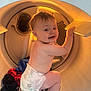 baby, diaper, laundry_dryer, clothing, child, indoor, curious, smiling, crawling, household, appliance, fabric, toddler, cute, playful, kid, face, skin, light, exploration