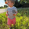 Nolan joined the competition — help win amazing prizes! toddler, child, flower, grass, sunlight, outdoor, nature, trees, road_sign, shorts, striped_shirt, portrait, smile, happy, summer, daylight, greenery, cute, playing, casual_clothing