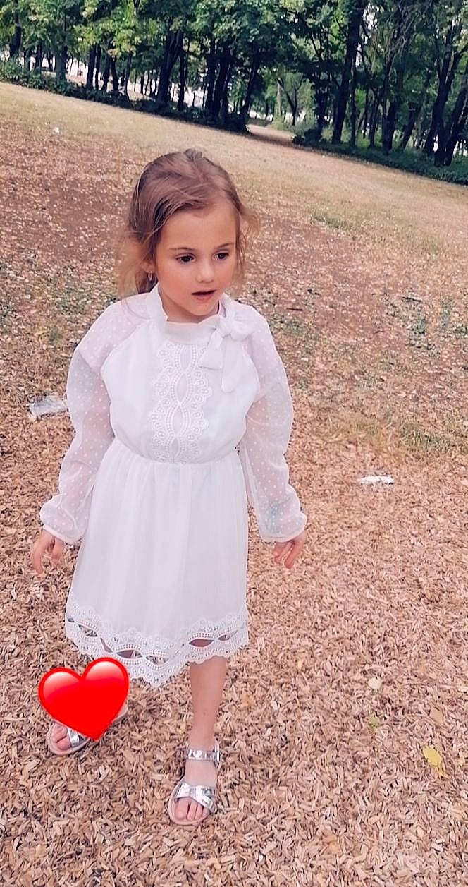 Kelya participe au concours pour gagner de l'argent avec cette photo : day_dress, dress, facial_expression, fashion, formal_wear, grass, happy, outerwear, people_in_nature, person, photograph, pink, plant, shoulder, sleeve, standing, street_fashion, textile, toy, tree