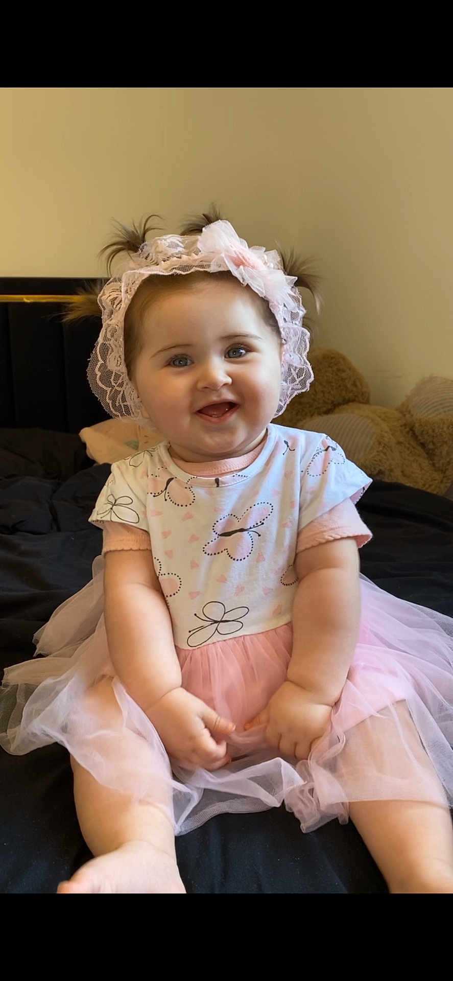 Sienna a rejoint le concours — aidez-le/la à gagner de superbes lots ! baby, bed, butterfly, child, clothing, cute, dress, happy, headband, indoor, infant, lace, person, pigtails, pink, plush_toy, portrait, sitting, smile, tutu