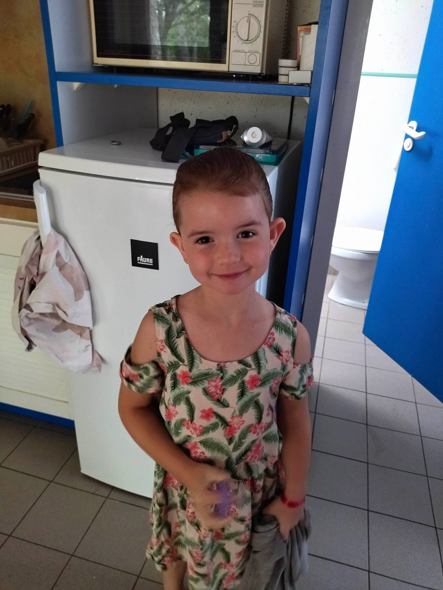 Aby participe au concours pour gagner de l'argent avec cette photo : blue, child, door, fashion_design, floor, flooring, fun, hairstyle, happy, joint, joy, kitchen, kitchen_appliance, pattern, person, room, sandal, shoulder, smile, sunglasses