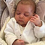 baby, sleeping, blanket, car_seat, clothing, infant, face, hand, soft_texture, cozy, child, portrait, peaceful, cute, resting, indoors, newborn, white_clothing, comfort, closeup