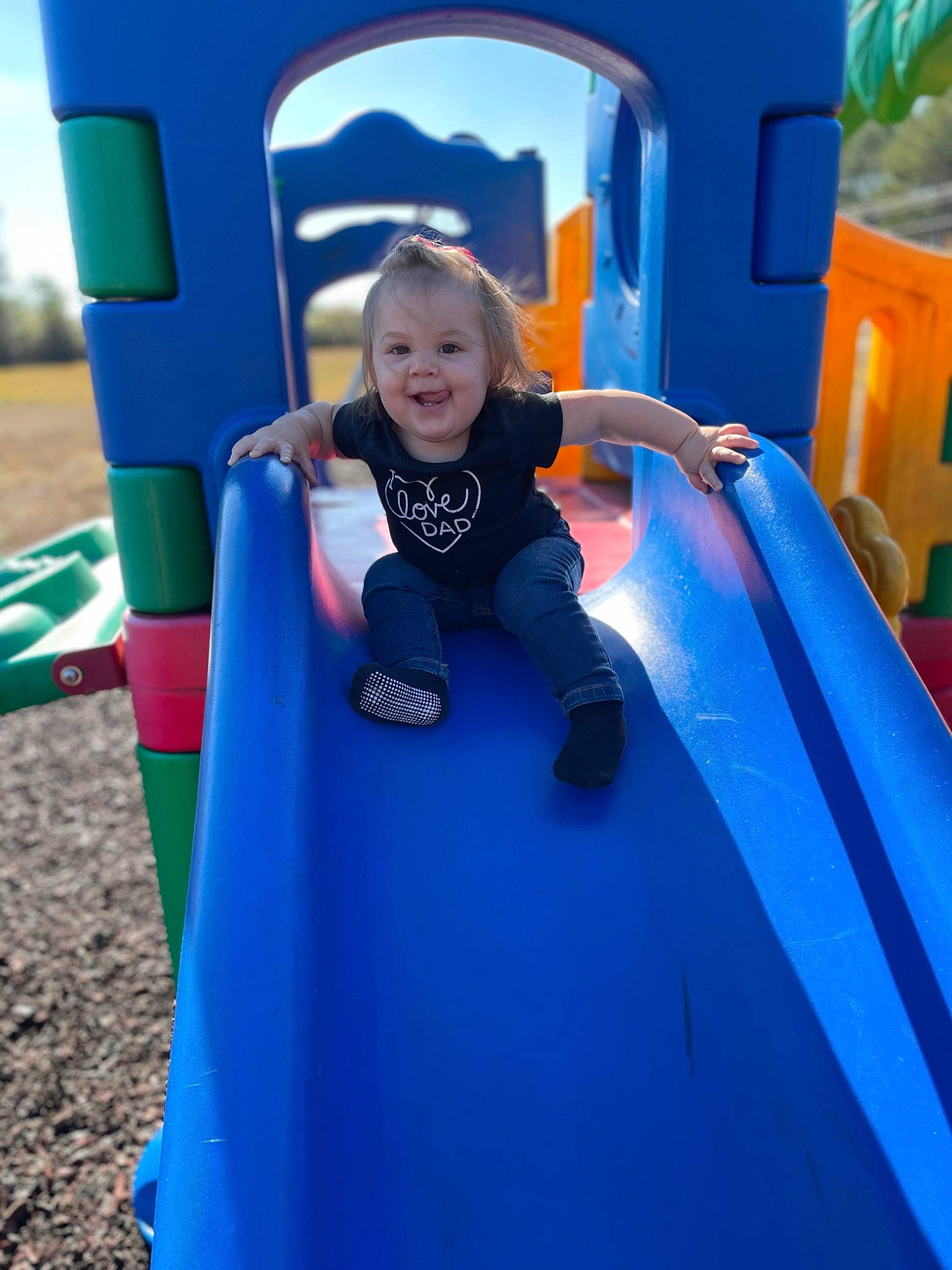 Kenzie is registered to the contest to win money with this photo: baby_toddler_clothing, blue, child, chute, city, electric_blue, fun, grass, happy, joy, leisure, outdoor_play_equipment, outdoor_recreation, person, play, playground, playground_slide, recreation, smile, t_shirt