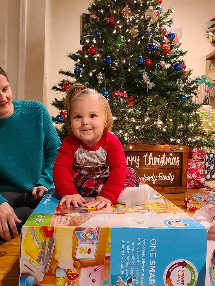 Kenzie is registered to the contest to win money with this photo: child, christmas, christmas_decoration, christmas_eve, christmas_ornament, christmas_tree, conifer, event, evergreen, happy, holiday, holiday_ornament, joy, ornament, person, plant, room, sharing, smile, snapshot