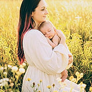 Aralynn is registered to the contest to win money with this photo: woman, baby, infant, field, wildflowers, nature, sunlight, golden_hour, outdoor, portrait, mother, child, holding, dress, peaceful, sleeping, grass, flower, tender, warm