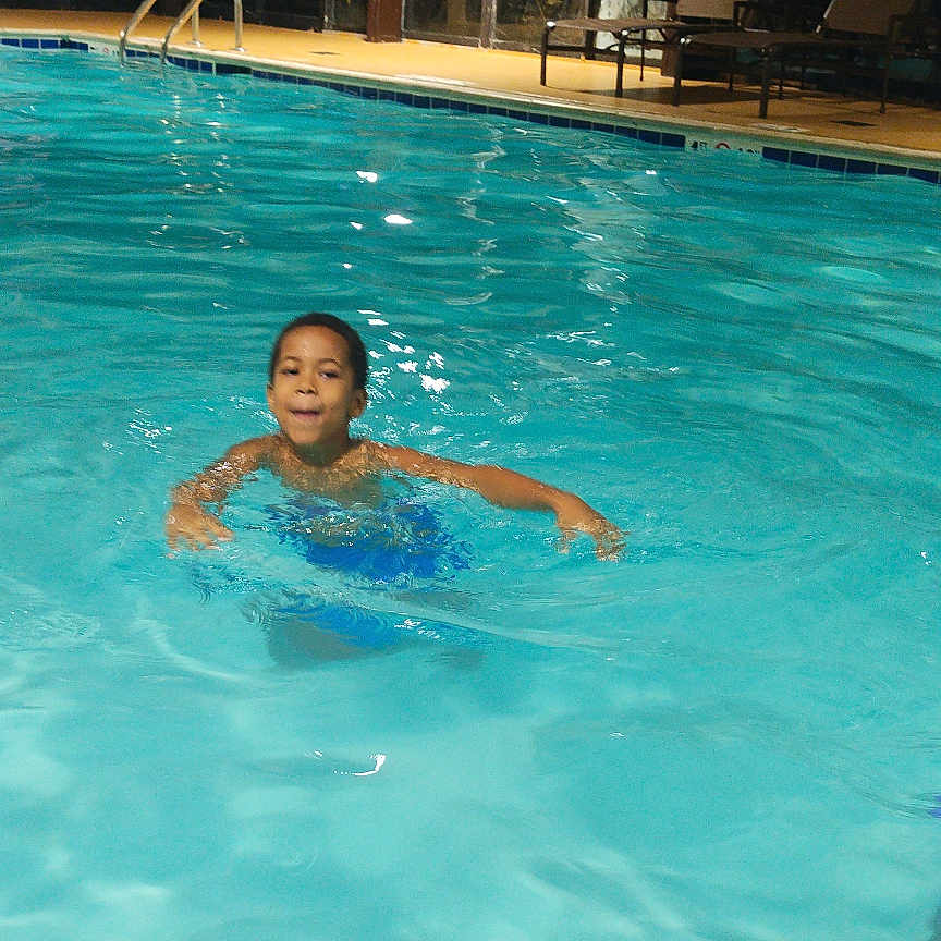 Prince Xaivier is registered to the contest to win money with this photo: activity, blue, child, fun, happy, indoor_pool, kids, leisure, motion, person, playful, poolside, purple_clothing, recreation, splash, summer, swimming, swimming_pool, water, wet_hair