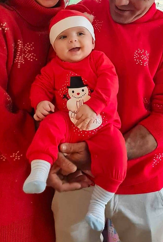 Stefan participe au concours pour gagner de l'argent avec cette photo : baby, baby_toddler_clothing, cap, child, christmas, event, face, facial_expression, happy, hat, headwear, lap, outerwear, person, pink, red, santa_claus, sleeve, smile, t_shirt