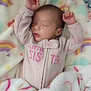 Amariah joined the competition — help win amazing prizes! baby, sleeping, infant, blanket, pink_onesie, little_sister, rainbow_pattern, heart_pattern, soft_texture, cozy, child, newborn, cute, peaceful, indoors, resting, hands_up, face, skin, clothing