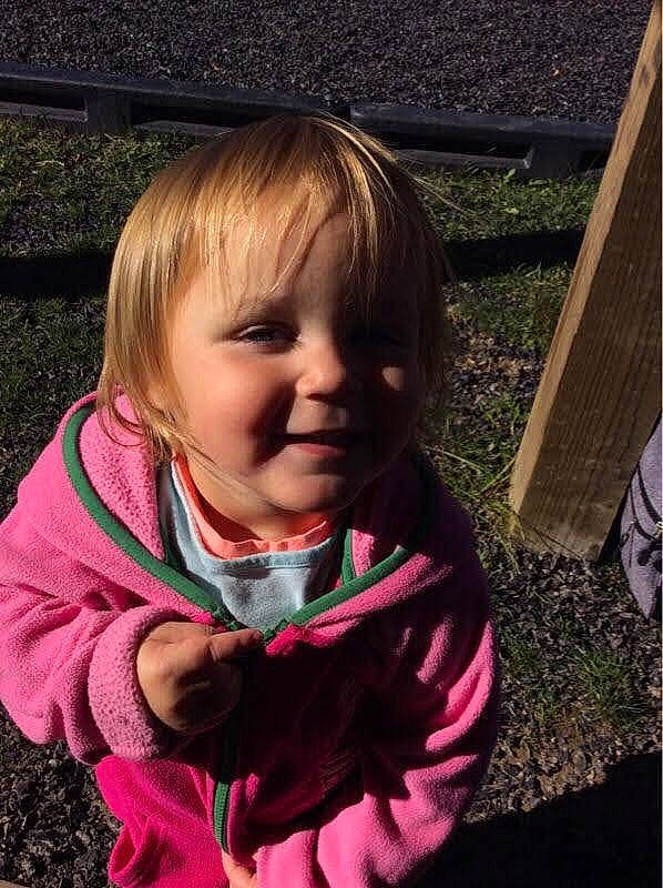 Carlie is registered to the contest to win money with this photo: baby, baby_toddler_clothing, blond, cheek, child, fun, grass, hair, happy, iris, joy, lip, magenta, nose, people_in_nature, person, pink, plant, play, sitting