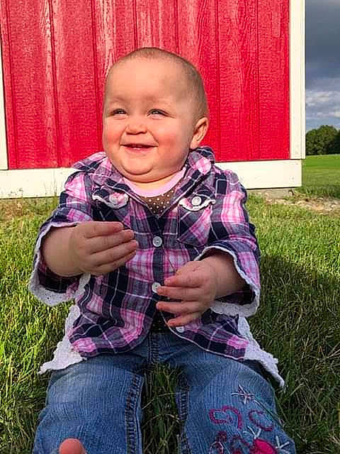 Carlie is registered to the contest to win money with this photo: baby, baby_toddler_clothing, child, clothing, eye, fun, grass, happy, joy, lawn, pattern, people_in_nature, person, pink, plaid, plant, purple, skin, sleeve, smile