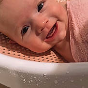 Josie joined the competition — help win amazing prizes! baby, infant, child, smiling, happy, portrait, face, eyes, teeth, bath, bath_seat, towel, pink, water_droplets, indoor, close_up, lying_down, warm_lighting, adorable, photography