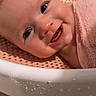 baby, infant, child, smiling, happy, portrait, face, eyes, teeth, bath, bath_seat, towel, pink, water_droplets, indoor, close_up, lying_down, warm_lighting, adorable, photography