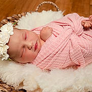 Gracie joined the competition — help win amazing prizes! newborn, baby, sleeping, swaddled, pink_blanket, headband, flower, basket, woven, fluffy, white_fabric, wooden_floor, peaceful, infant, portrait, cute, soft_texture, resting, indoors, cozy