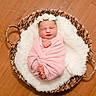 Gracie joined the competition — help win amazing prizes! newborn, baby, sleeping, wrapped, pink_blanket, flower_crown, basket, woven, fluffy, white_fabric, wooden_floor, peaceful, cute, infant, portrait, cozy, indoors, soft_texture, resting, child