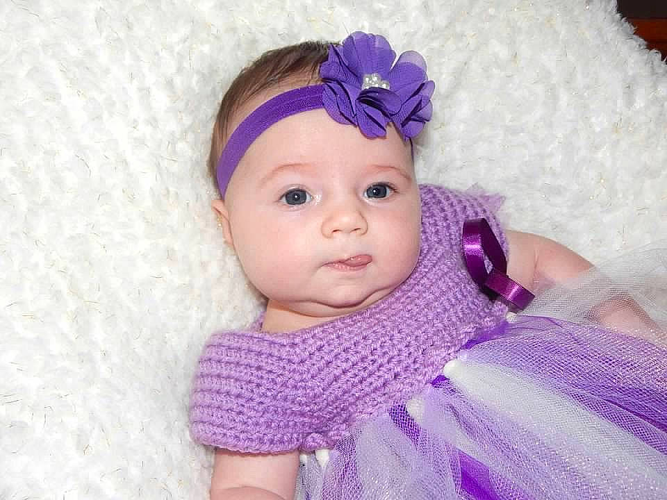 Alivia is registered to the contest to win money with this photo: baby, baby_toddler_clothing, child, clothing, crochet, dress, face, fashion_accessory, hair_accessory, head, headband, headgear, headpiece, lavender, lilac, person, pink, purple, textile, toddler
