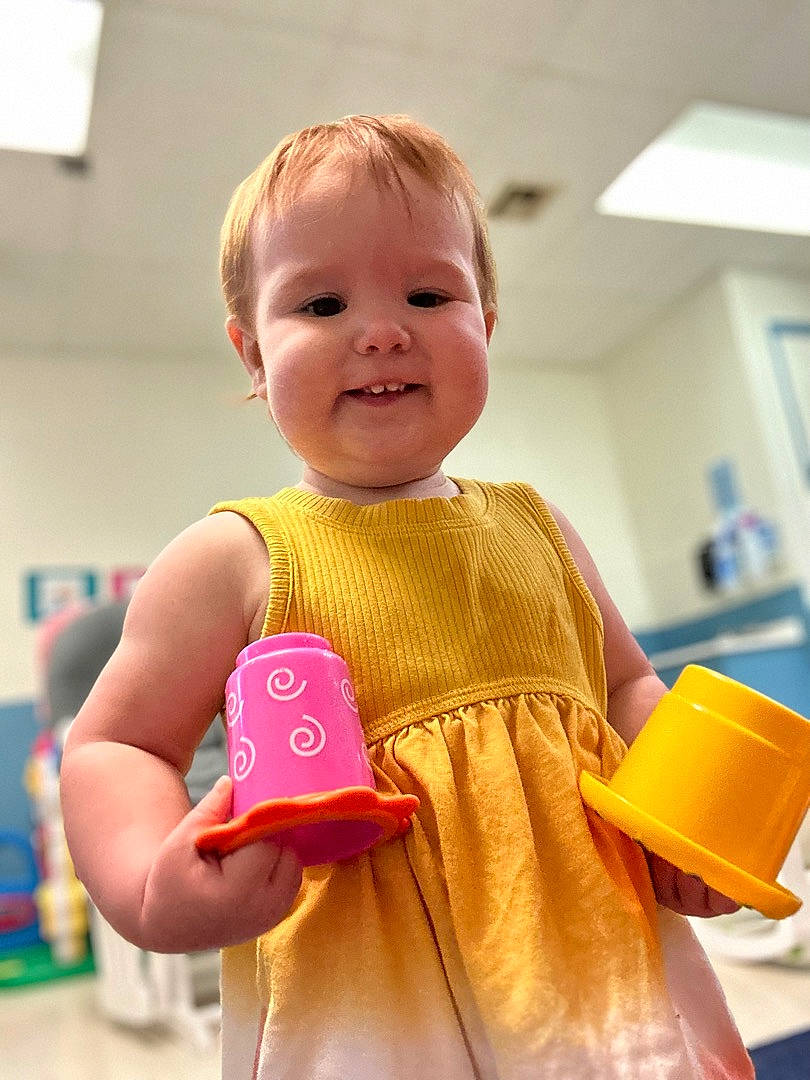 Georgia is registered to the contest to win money with this photo: baby, baby_toddler_clothing, child, dress, event, facial_expression, fun, gadget, happy, joy, leisure, magenta, pattern, person, play, room, sleeve, smile, t_shirt, toddler