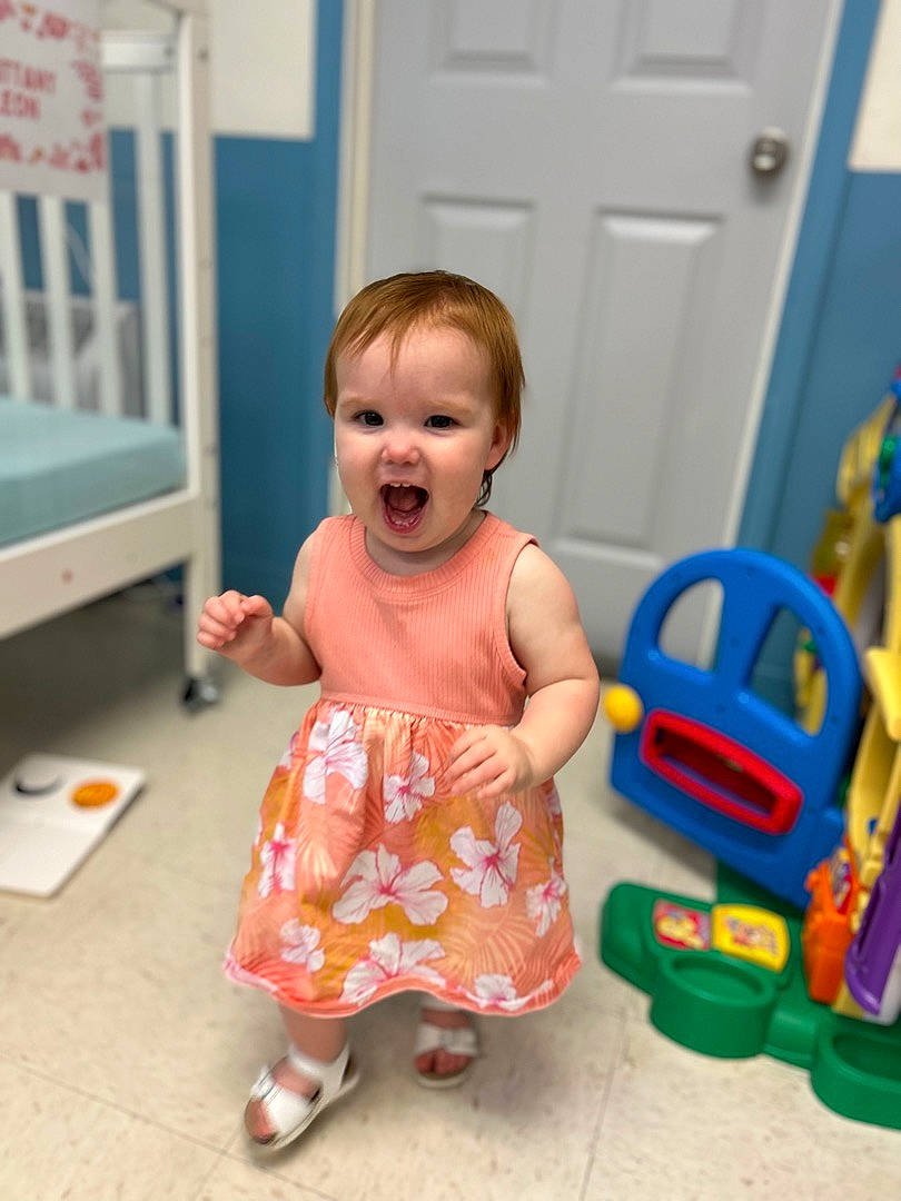 Georgia joined the competition — help win amazing prizes! baby, baby_playing_with_toys, baby_products, baby_toddler_clothing, baby_toys, blue, child, door, flooring, fun, happy, person, plastic, play, riding_toy, room, sandal, sitting, smile, toddler