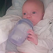 Kiarra is registered to the contest to win money with this photo: baby, bed, beverage, blanket, cradle, crib, cup, cushion, face, furniture, head, homedecor, infantbed, jug, milk, newborn, person, photography, portrait, waterjug