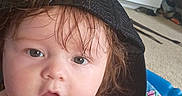 Jaxson joined the competition — help win amazing prizes! baby, child, infant, portrait, close_up, face, eyes, brown_hair, black_cap, bare_shoulders, sitting, indoors, couch, blanket, colorful_pattern, home, carpet, furniture, photography, cute