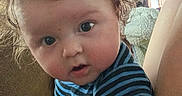 Jaxson joined the competition — help win amazing prizes! adult, baby, blue_clothing, child, close_up, couch, curly_hair, daylight, face, family, home, indoor, infant, messy_hair, portrait, sitting, sofa, striped_onesie, wide_eyed, window