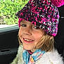Erin participe au concours pour gagner de l'argent avec cette photo : child, smiling, hat, knitted_hat, pom_pom, scarf, floral_scarf, sweater, white_sweater, car_interior, window, greenery, face, person, happy, portrait, young_child, seated, casual_clothing, indoor