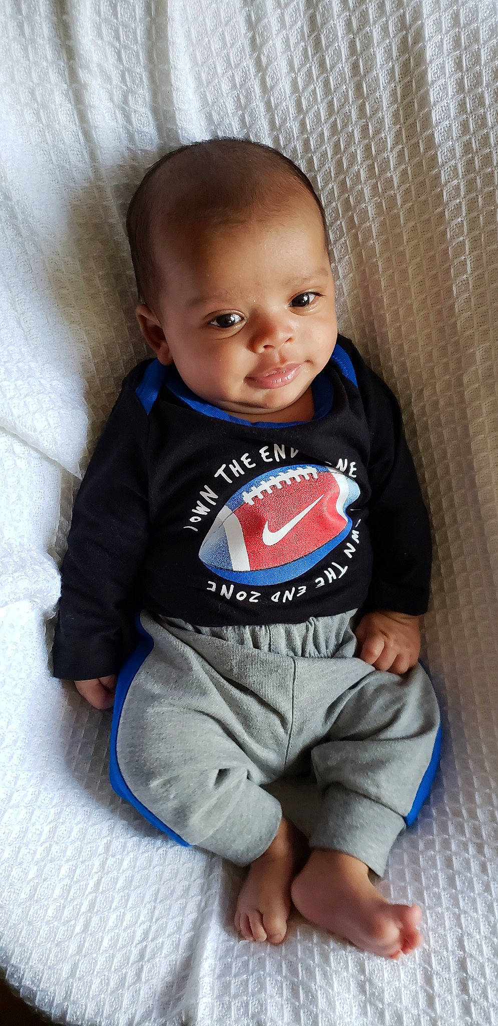 Jasiah is registered to the contest to win money with this photo: baby, baby_products, baby_toddler_clothing, cheek, child, outerwear, person, product, sitting, sleeve, smile, t_shirt, toddler