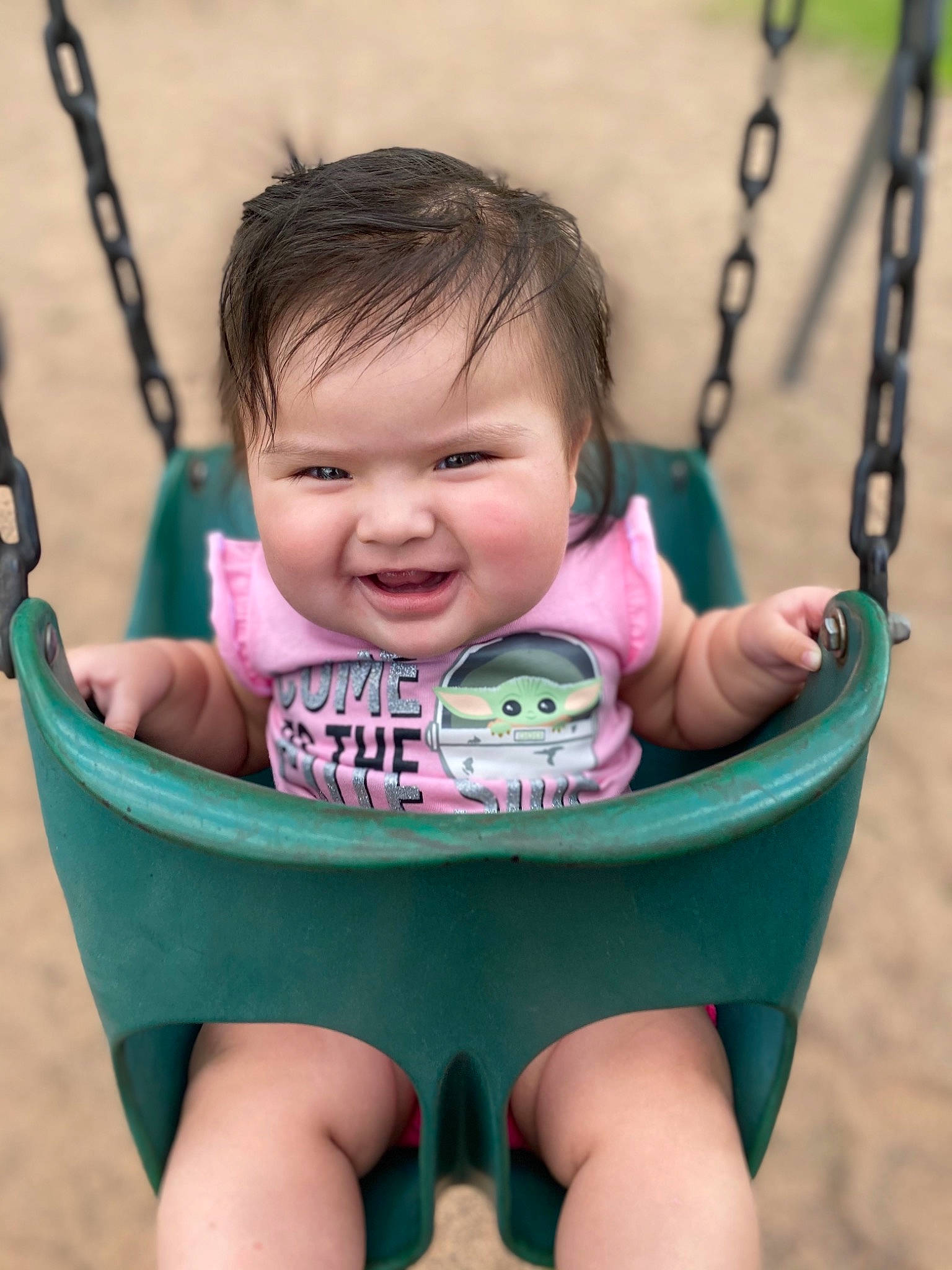 Sky is registered to the contest to win money with this photo: baby, black, blue, cheek, chin, eye, face, facial_expression, green, hair, hairstyle, head, human_body, lip, mouth, organ, person, photograph, skin, swing